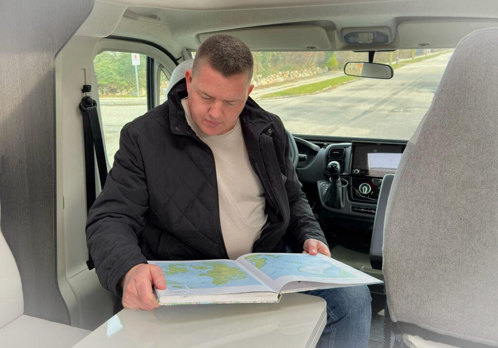 Rasmus Neslein reading a map inside a campervan while exploring Denmark